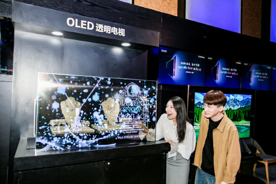 19일 중국 베이징에서 열린 'OLED 빅뱅 미디어 데이 행사'에서 참석자들이 LG디스플레이의 55인치 투명 OLED 디스플레이를 관람하고 있다.  LG디스플레이 제공